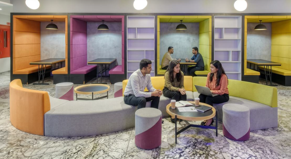 Diverse seating options including open booths and modular curved sofas for different engagement styles